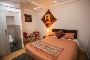 a bedroom with a bed and a bathroom with a toilet at RumiUma Boutique Hotel in Cusco