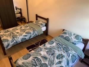 two beds in a room with two bedsskirts at Chaleureux logement familial jusqu'à 6 personnes in Annemasse