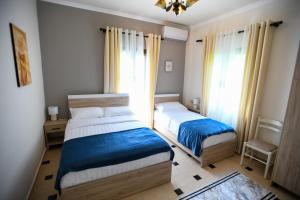 um quarto com 2 camas e uma janela em Villa Solitude em Berat