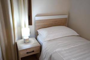 um quarto com uma cama e uma mesa de cabeceira com um candeeiro em Villa Solitude em Berat