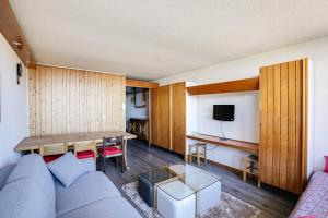 salon z niebieską kanapą i stołem w obiekcie Résidence Adret - Appartement 6 personnes à Arc 1600 proche des pistes et des commerces. MAE-1893 w mieście Arc 1600