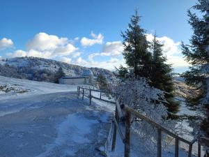 a snow covered road with a fence and a building at Rifugio Guglielmo e Giovanni Pelizzo in Montemaggiore +39 photos