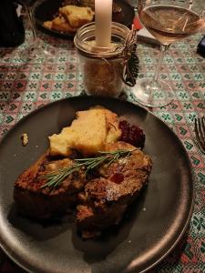 una bistecca su un piatto su un tavolo con una candela di Rifugio Guglielmo e Giovanni Pelizzo a Montemaggiore
