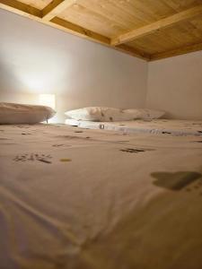 two beds in a room with a wooden ceiling at Rifugio Guglielmo e Giovanni Pelizzo in Montemaggiore