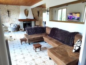 ein Wohnzimmer mit einem Sofa und einem Kamin in der Unterkunft Maison de 3 chambres avec piscine privee jardin clos et wifi a Paimpont in Paimpont