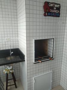 a bathroom with a sink and a fire place in the wall at Apartamento frente mar pé na areia in Praia Grande