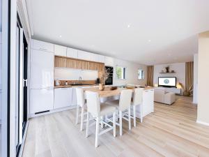 a kitchen with a wooden table and white cabinets at Le Ruffa in Bohars