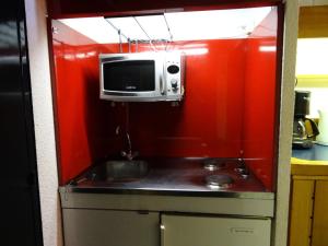 a small kitchen with a microwave and a sink at Résidence Les Arolles - Studio 4 personnes à Arc 1600 en centre station et proche des pistes MAE-1953 in Arc 1600