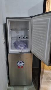 a small refrigerator with its door open in a room at Pentagon Court Phase 1 Apartment Ikota in Lagos