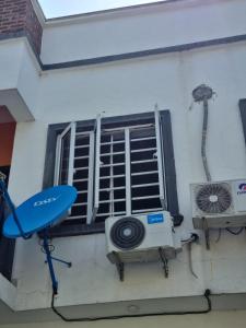 a window with a air conditioner and a fan at Pentagon Court Phase 1 Apartment Ikota in Lagos