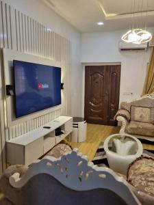 un soggiorno con TV a schermo piatto a parete di Pentagon Court Phase 1 Apartment Ikota a Lagos