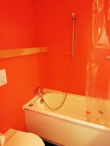 a red bathroom with a toilet and a bath tub at Résidence Grand Arbois - Studio pour 4 Personnes 57 in Arc 1800