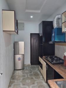a kitchen with a refrigerator and a stove at Pentagon Court Phase 1 Apartment Ikota in Lagos