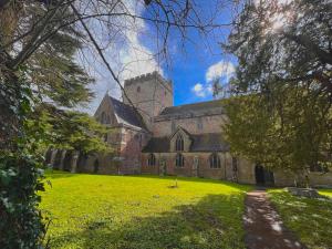 an old church with a grassy yard in front of it at Brecon serviced apartments- Kian Perrott Properties in Brecon