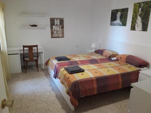 a bedroom with a bed and a desk and a table at Helle moderne Ferienwohnung 500m v.Meer in Almería
