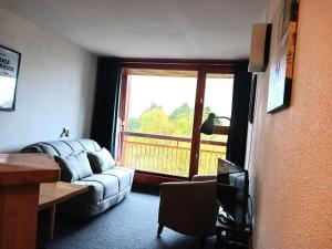 ein Wohnzimmer mit Couch und großem Fenster in der Unterkunft Résidence Bel Aval - Studio pour 4 personnes à Arc 2000 proche des pistes, des commerces et de la patinoire MAE-1965 in Arc 2000