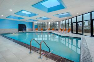 a pool in a hotel with blue ceilings and windows at Crowne Plaza Auburn Hills, an IHG Hotel in Auburn Hills