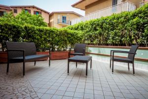 3 sillas y una mesa en un patio en Settessenze Residence & Rooms, en Agropoli