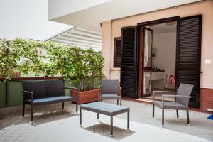 un grupo de sillas y mesas en un patio en Settessenze Residence & Rooms, en Agropoli