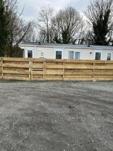 a wooden fence in front of a house at Hideout caravan in Llangristiolus