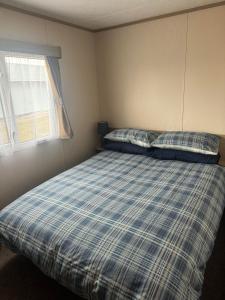 a bedroom with a bed with two pillows and a window at Highway in Lossiemouth