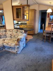 a living room with a couch and a table at Hideout caravan in Llangristiolus