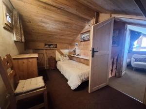 a bedroom with a bed in a wooden cabin at Chalet De Bellecote - Chalets pour 8 Personnes 96 in Peisey-Nancroix