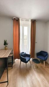 een kamer met 2 stoelen, een bureau en een raam bij Lorient, Studio Centre, Fibre Proche Gare, Plage in Lorient