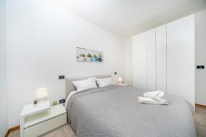 a white bedroom with a bed and a white cabinet at La Casetta di Bubi in Udine