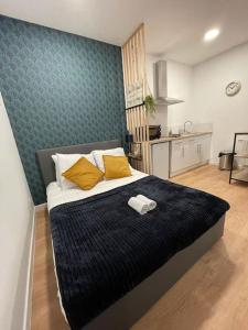 - une chambre avec un grand lit et des oreillers jaunes dans l'établissement Lorient, Studio Centre, Fibre Proche Gare, Plage, à Lorient