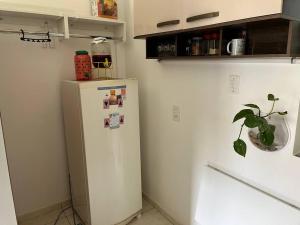 einen weißen Kühlschrank in einer Küche mit einer Pflanze darauf in der Unterkunft Práctico apto em Ipanema para descansar in Rio de Janeiro