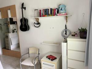 Zimmer mit einem Stuhl, einem Tisch und einer Gitarre in der Unterkunft Práctico apto em Ipanema para descansar in Rio de Janeiro