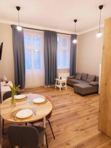 a living room with a table and a couch at Justinrent 3 in Legnica +9 photos