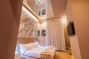 a hotel room with a bed and a tv at Maximum hub suite&spa in Palermo