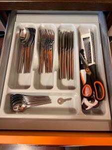a white tray with utensils in a drawer at Coco Apartment in Bergamo