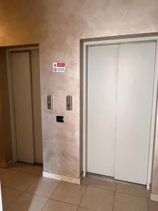 two elevator doors in a building with a sign on the wall at Coco Apartment in Bergamo