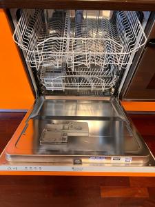 a dishwasher with a drying rack in it at Coco Apartment in Bergamo