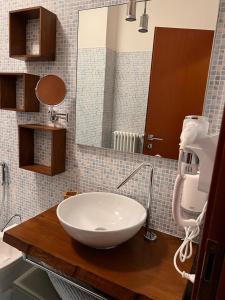 a bathroom with a white sink and a mirror at Coco Apartment in Bergamo