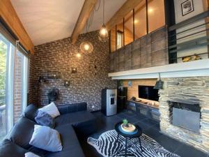a living room with a blue couch and a fireplace at Woody Lodge - Duplex Nature Bonsoy Ardennes in Hastière-par-delà