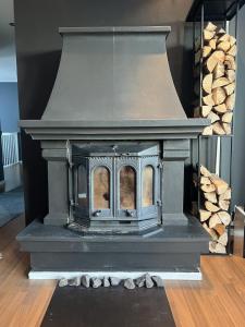 a grey fireplace with logs in the background at All inclusive villa in Lillehammer