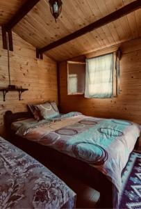 - une chambre avec un lit dans une cabane en bois dans l'établissement Camping Mala Clisura Dunării, à Eşelniţa