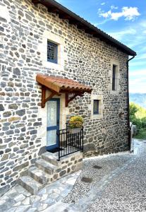 Casa de piedra con balcón y ventana en Gîte Le Nid d'Ange en Le Chier