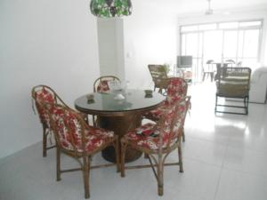 a dining room with a table and chairs at Marisia in Guarujá