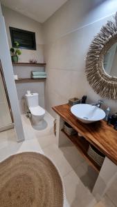y baño con lavabo, aseo y espejo. en Raahere Lodge - near the city center, en Papeete
