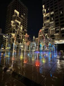 a water fountain in a city at night at Dutch Luxury Apartment - Private Beach in Abu Dhabi
