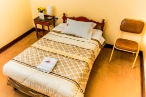 a small bedroom with a bed and a chair at Hotel Independencia in Huaraz