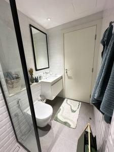 ein Badezimmer mit einem WC, einem Waschbecken und einem Spiegel in der Unterkunft Dutch Luxury Apartment - Private Beach in Abu Dhabi