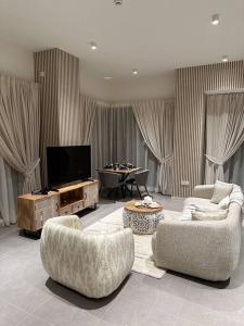 a living room with two couches and a flat screen tv at Dutch Luxury Apartment - Private Beach in Abu Dhabi