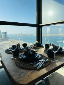 einen Tisch mit Teller mit Speisen und Weingläsern in der Unterkunft Dutch Luxury Apartment - Private Beach in Abu Dhabi