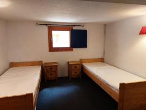 dwa łóżka pojedyncze w pokoju z oknem w obiekcie Résidence Vogel - Chaleureux duplex pour 4 personnes avec une très belle vue sur la vallée dans le village de Charmettoger à Arc 1800 MAE-2129 w mieście Arc 1800